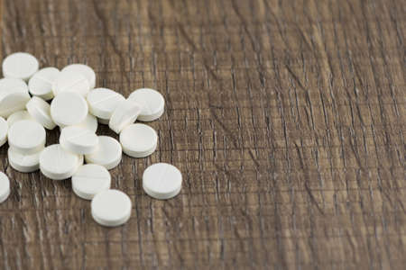 treatment chemicals: a bunch of pills lying on the wooden table, placing the right sideの写真素材