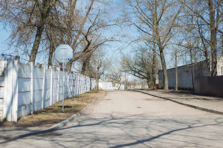 old white high concrete fence along the sidewalkの写真素材
