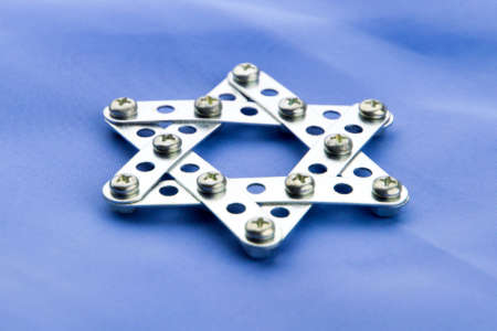 Judaism: star of David, built with meccano, lies on blue fabric, front view, short focus