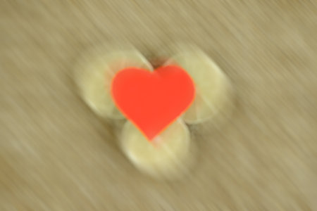 easy to love: the scarlet heart is beating in self-sewed a linen fabric Golden brown color of natural linen, decorated with 3 slices of dried lime, shot with motion effectの写真素材