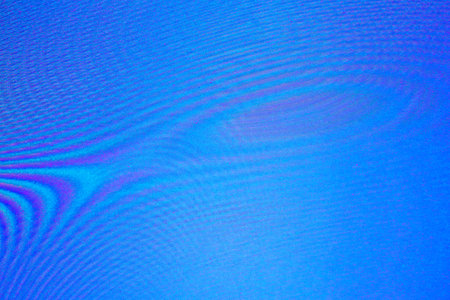 An abstract dark blue background with waves, interference, moireの写真素材