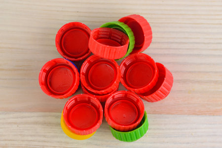 Multicolored plastic caps on wooden background