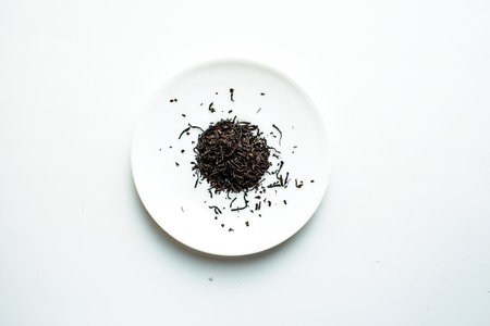 5 o'clock: a small pile of black leaf tea for brewing on a white plateの写真素材