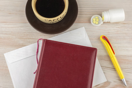 ensuring good employee: a pack of tablets of ephedrine, Cup of strong coffee. nearby is a wooden table on the envelope, Notepad and penの写真素材