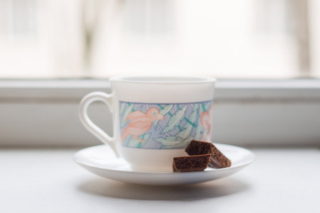 a Cup of fresh hot coffee and a pair of porous chocolate bars on a plate, on the background of the...
