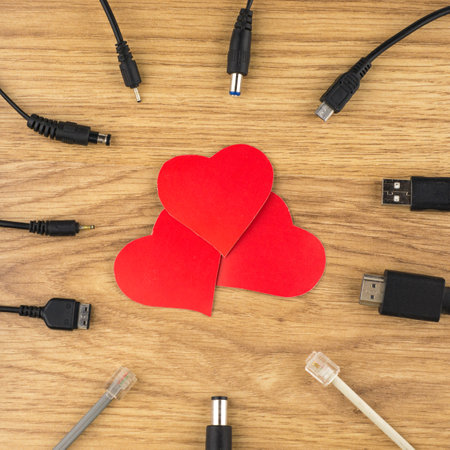waiting for love bonds: 3 red hearts and lots of different plugs and charger that can't connect to itの写真素材
