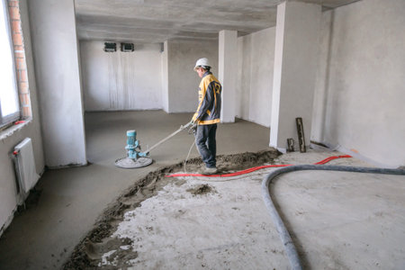 Builder in work clothes prepares tools and materialsの写真素材