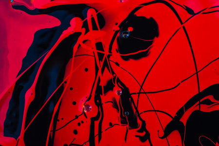 abstract red and black background with paint splashes and drops.の写真素材