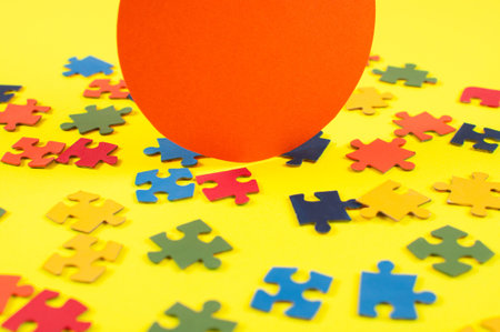Colorful jigsaw puzzle pieces on yellow background with one piece missing