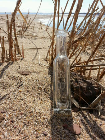 Empty rum bottle on the beach.の素材