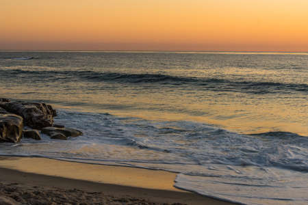 Golden sky, ocean, and beach at dusk seascape photograph