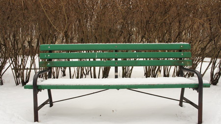 Snow on the bench in winter in park.の写真素材