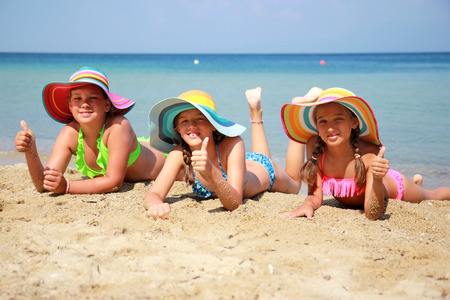 Girl with colorful hat on the beachの写真素材