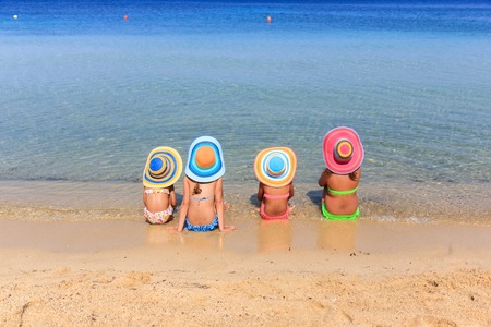 Girls with colorful hats on the beachの写真素材