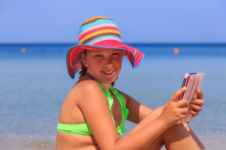 Girl with tablet on the beachの写真素材