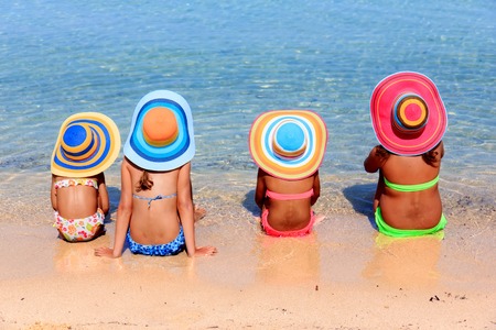 Girls with colorful hats on the beachの写真素材