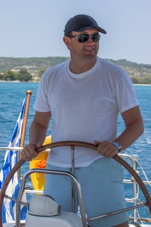 Skipper on sailboat navigating in mediterranean seaの写真素材