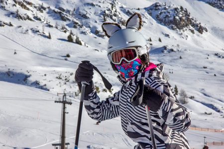 Girl on the ski slope with ears on the helmetの写真素材