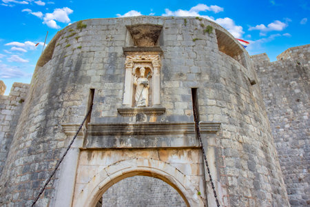 A frontal view of Bokar Castle, a prominent medieval fortress in Dubrovnik, Croatia, with its stone walls, historic gate, and a pedestrian bridge leading into the old city. A classic representation of Croatiaâs architectural and cultural heritage.の写真素材