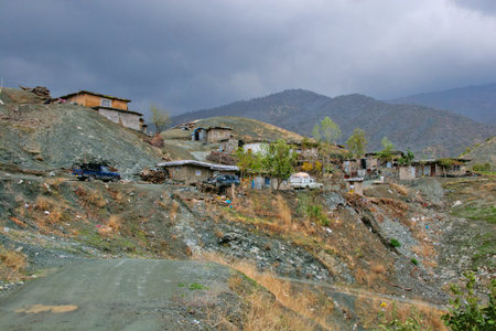 Traditional rural life in a Kurdish village, featuring a weathered stone and wood shelter and a dirt pathの写真素材