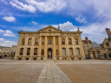 A grand historic college building in Oxford stands under a bright blue skyの写真素材