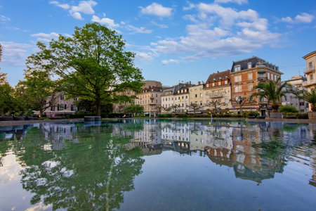Augustaplatz in Baden-Baden, dominated by the large, glassy surface of a fountain or decorative pond in the foregroundの写真素材