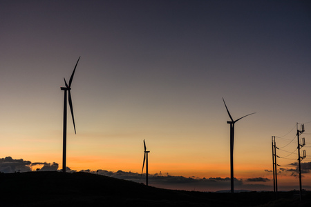 Silhouette wind generators turbines on sunset summer landscape in Thailandの写真素材