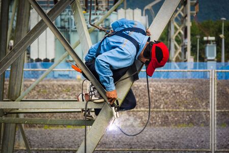 Welder work at high Electric high voltage pole 230 Kvの写真素材