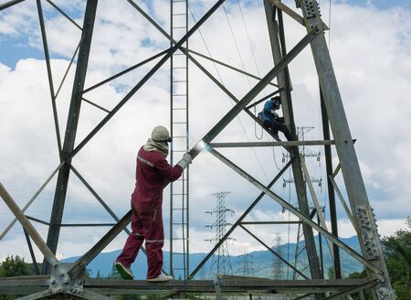 Welder work at high Electric high voltage pole 230 Kv