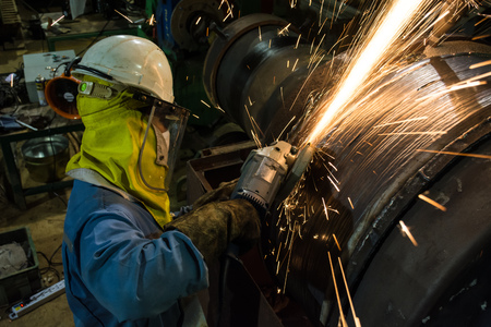 Worker metal grinding machine repair weld at steel rollの写真素材