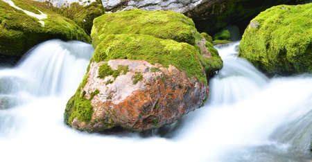 Long exposure image of a mountain stream flowing trough stone.