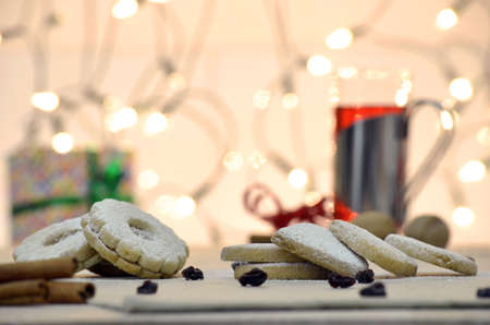 Christmas sweets on a table decorated with lights in background の写真素材