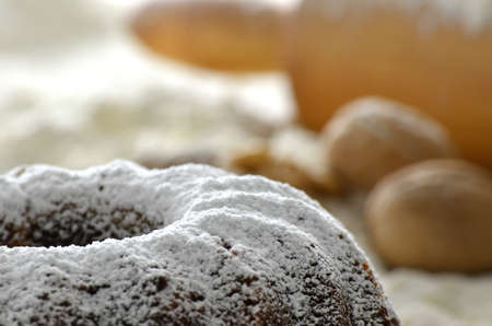 Closeup of a  Christmas cake with flour,rolling pin and walnuts in the background の写真素材