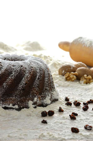 Christmas cake on wheat flour  Rolling pin and walnuts in the background の写真素材