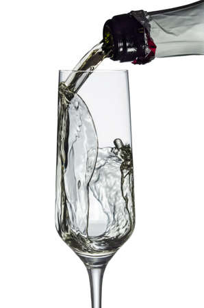 Champagne being poured into a glass, isolated on white background の写真素材
