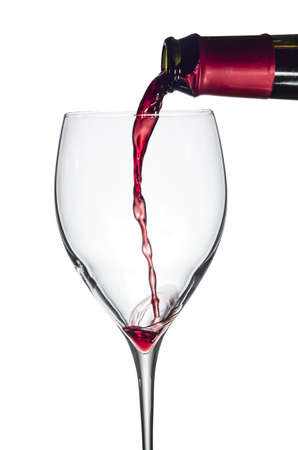 Red wine being poured into a glass  Isolated on white background の写真素材