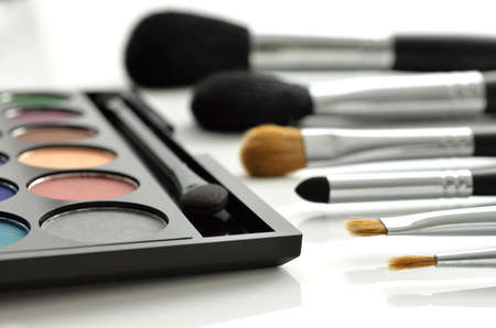 Makeup brushes and eye-shadows palette on white backgroundの写真素材