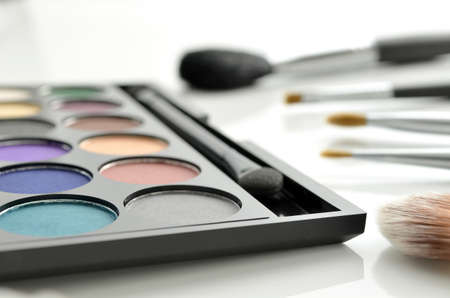 Eyeshadow palette and makeup brushes on white background の写真素材