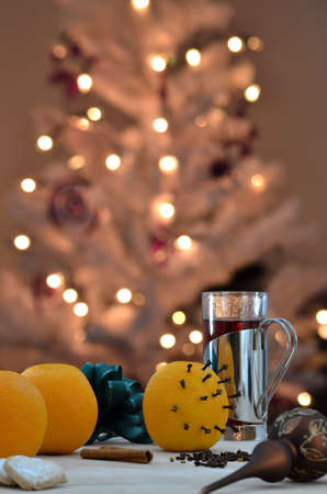 Oranges with christmas decoration on a wooden table  Blurred lights on a white Christmas tree in background の写真素材