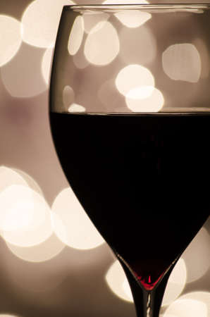 Closeup of a red wine with defocused lights in background の写真素材