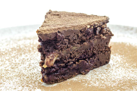 Closeup of a delicious vegan cake on a white plate decorated with cocoa  の写真素材