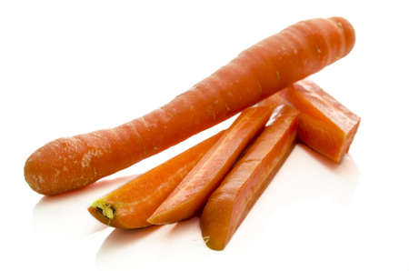 One whole carrot and one cut into pieces isolated on white の写真素材