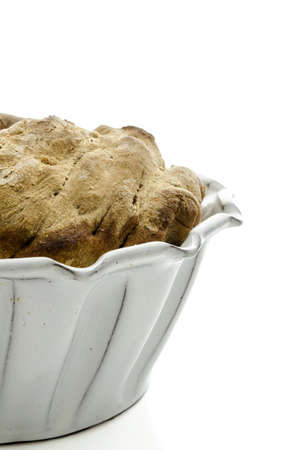 Closeup of a homemade bread in a baking pan isolated on a white background の写真素材