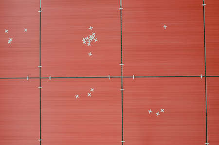 Top view of unfinished red ceramic tiles with tile spacers の写真素材