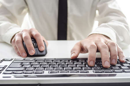 Closeup of a man using computer  His shirt and tie in background  の写真素材