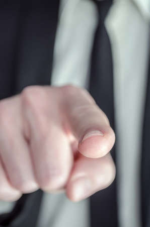 Closeup of a businessman pointing his finger at you の写真素材