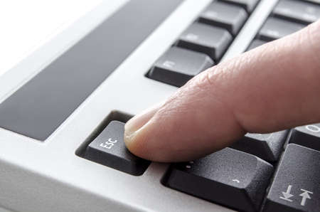 Closeup of a finger pushing escape key の写真素材