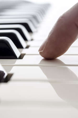 Detail of one male finger touching a piano key の写真素材