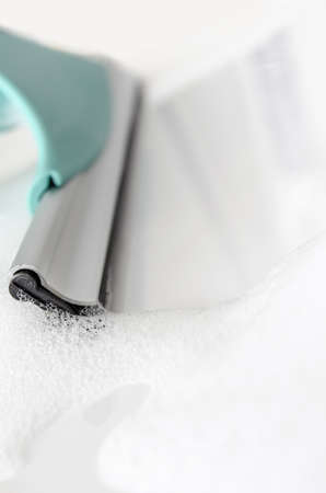 Detail of cleaning white ceramic tiles with rubber window cleaner の写真素材