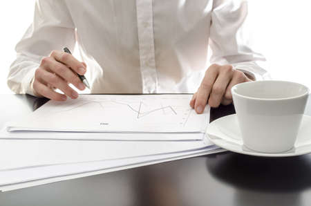 Businessman analyzing financial reports on an office desk.の写真素材